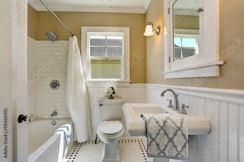 Valokuva American bathroom interior in white tones and tile floor.