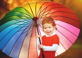 Wall Mural - happy little child girl with multicolored rainbow umbrella in pa