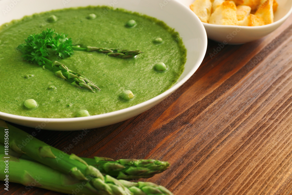 Tasty asparagus soup on table