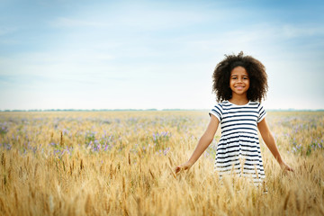 Happy little African American girl in the field