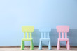Three children chairs on blue wall background