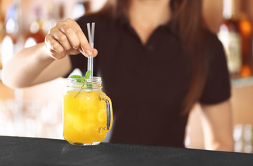 Poster - Woman hands putting straws into cocktail on bar counter