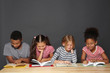 © Africa Studio - Cute kids reading books on grey background