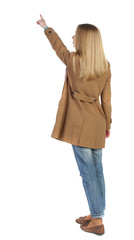 Wall Mural - Back view of  pointing young women in parka. Young girl gesture. Rear view people collection.  backside view of person.  Isolated over white background. The blonde in a brown raincoat is pointing to