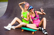 Fashion glamor stylish swag young girl model blonde and brunette with perfect tanned bodies in bright sexy bathing suits in a skate park, Long board, lady laughing and having fun, licking lollipops