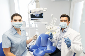 Wall Mural - close up of dentist and assistant at dental clinic