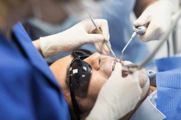 Wall Mural - close up of dentists treating teeth at clinic