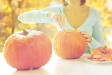 Wall Mural - close up of woman carving pumpkins for halloween