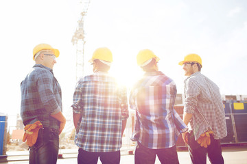 Poster - group of smiling builders in hardhats outdoors