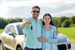 happy man and woman with car key hugging 