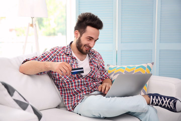 Wall Mural - Man using credit card and laptop for online shopping