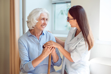 Young nurse embracing senior woman