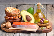 Selection of healthy fat sources on wooden background.