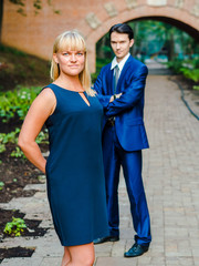 Couple standing on the background of an old brick arch bridge