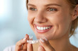 © puhhha - Smiling Woman With White Teeth Holding Teeth Whitening Tray. High Resolution Image