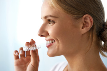 Wall Mural - Smiling Woman With Beautiful Smile Using Invisible Teeth Trainer. High Resolution Image