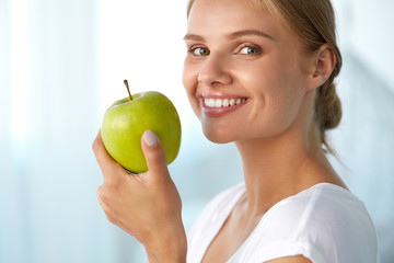 Wall Mural - Woman With Apple. Beautiful Girl With White Smile, Healthy Teeth. High Resolution Image