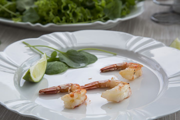 Fried shrimp with lemon on a white plate oven old wooden backgro