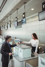 Businessman Showing Mobile Boarding Pass To Airline In Airport