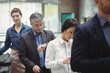 © Wavebreak Media - Passengers waiting in queue at a check-in counter with luggage