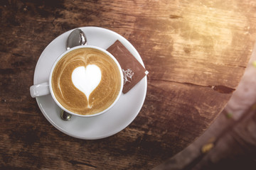 A Cup of hot latte art coffee with heart  Shape on wooden table