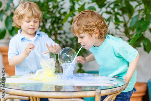 Fotografie, Obraz two twin boys making experiment with colorful bubbles