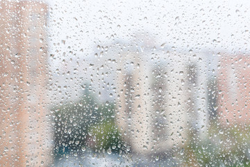 Wall Mural - view of raindrops on window glass of urban house