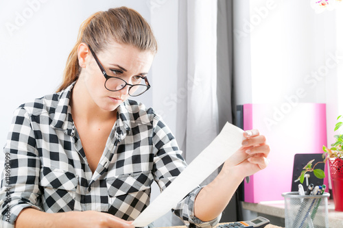 Fotografia, Obraz Woman calculating and paying bills in home office