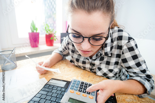 Fotografia, Obraz Woman calculating and paying bills in home office