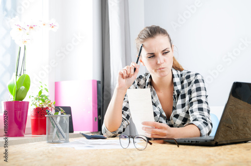Obraz na plátne Woman calculating and paying bills in home office