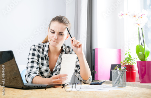 Fotografia, Obraz Woman calculating and paying bills in home office