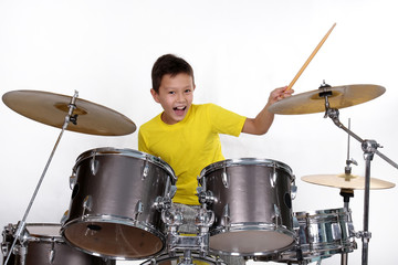 Happy young boy playing drums