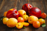 Stone fruits on wooden background. Yellow plums, apricots and nectarines