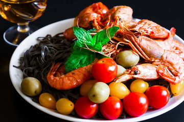 food. black pasta, shrimps, cherry tomatoes, white wine, black b