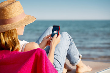 Woman with handy on the seaside