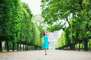 Wall Mural - Beautiful young woman walking in Parisian Tuileries park