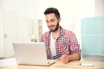 Wall Mural - Man using credit card and laptop for online shopping