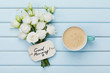 © juliasudnitskaya - Coffee mug with white flowers and notes good morning on blue rustic table from above. Beautiful breakfast. Flat lay.