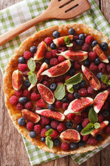 Wall Mural - tart with fresh fruit and berries close up on the table. vertical top view
