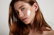 young model with cream on cheek