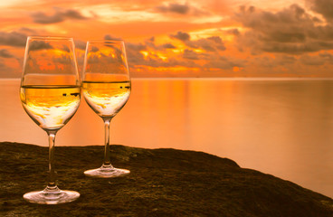 Wall Mural - Pair of wine glasses against a beautiful tropical sunset. 