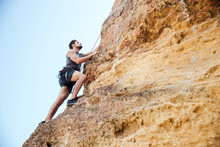 Young Man Climbing Natural Rocky Wall