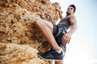 © Drobot Dean - Young man climbing natural rocky wall