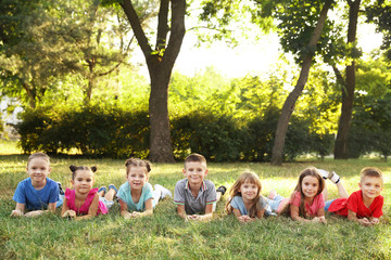 Wall Mural - Happy kids lying on grass in park