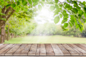 Empty wooden table with garden bokeh for a catering or food background with a country outdoor theme,Template mock up for display of product