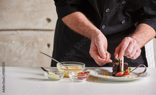 Zdjęcie XXL Restauracyjny hotel prywatny szef kuchni przygotowywa pustynnego czekoladowego tort