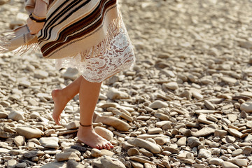 beautiful woman traveler walking barefoot  at river beach, legs