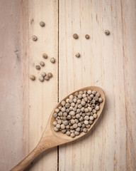 Sticker - White pepper seeds in spoon on the wood table