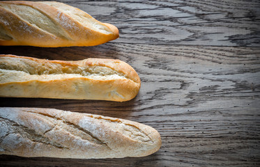 Canvas Print - Three baguettes on the wooden background