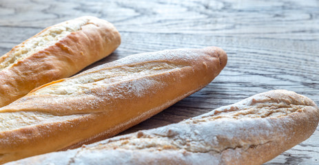 Poster - Three baguettes on the wooden background